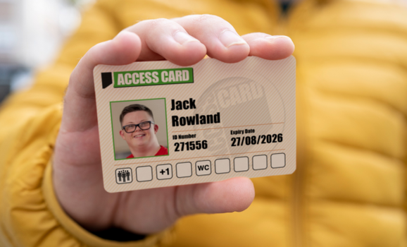 A hand holds up a an Access Card which has a picture of the person, their name and the access needs that they require.