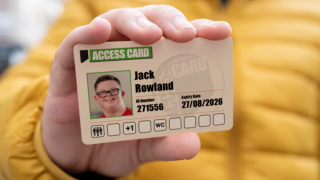 A hand holds up a an Access Card which has a picture of the person, their name and the access needs that they require.