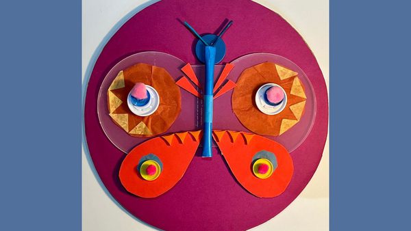 Blue background with a crafted cardboard collage of a butterfly in purple, blue, red and pink
