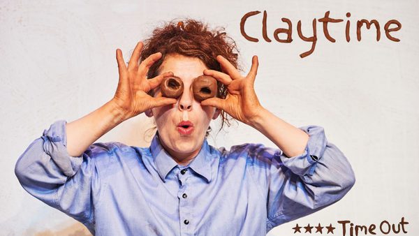 A lady wearing a blue shirt, holds 2 clay 'eyeballs' to her face, with a surprised expressed#! The show title 'Claytime' is displayed proudly on top of a 4 star review from Timeout.