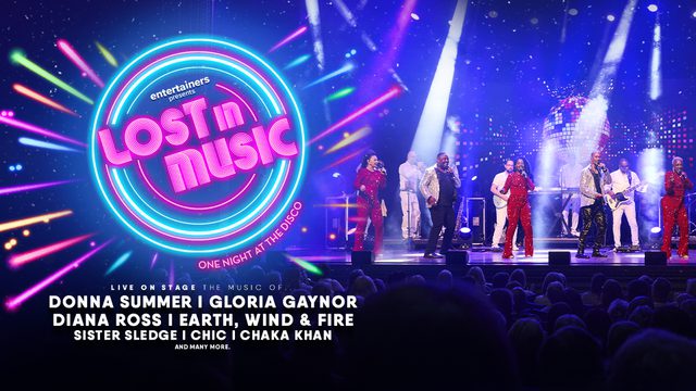 The title in bright pink neon letters 'Lost in Music' is shown on the left inside a circle of colourful blue, pink and green neon lights. An image of singers on stage with a large audience is shown on the right. The singers are wearing red jumpsuits and are bathed in theatrical lighting.