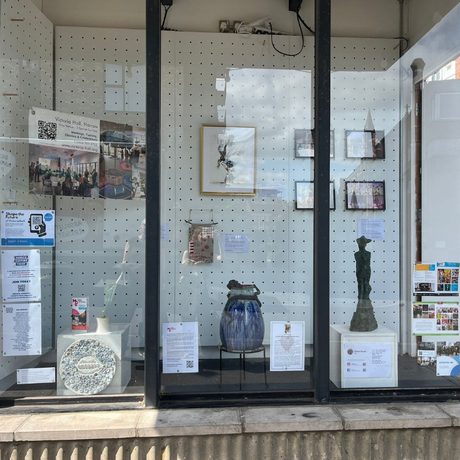 Small studio space behind a glass window displaying statues and various other art projects.