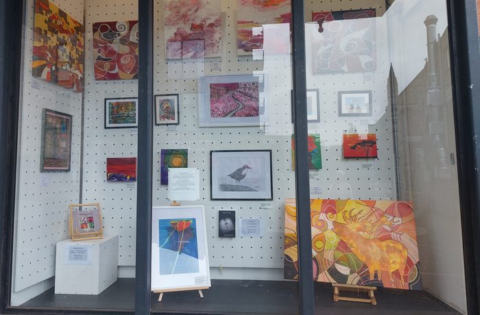 Colourful Artwork displayed behind glass of the Greenhill Art Pod in Harrow