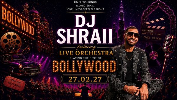 A man, DJ Shraii, sits in front of a microphone, wearing sunglasses, a denim jacket and jeans, smiling to the camera. The title 'DJ Shraii, featuring Live Orchestra, playing the best of Bollywood' is displayed in the centre