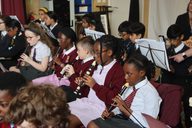 A group of young children playing recorders.