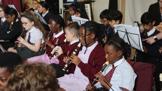 A group of young children playing recorders.