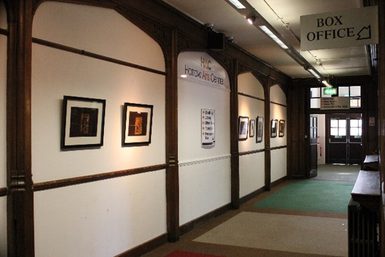 Corridor with white walls and paintings hanging on the walls