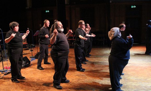 A group of performers on stage dancing.