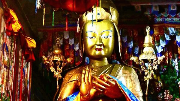 Golden statue inside a richly decorated Tibetan shrine, with the figure seated and holding hands in a ritual gesture. Colorful banners, hanging ornaments, and ceremonial objects surround the statue, representing the Lelung lineage, one of Tibet’s oldest spiritual traditions.