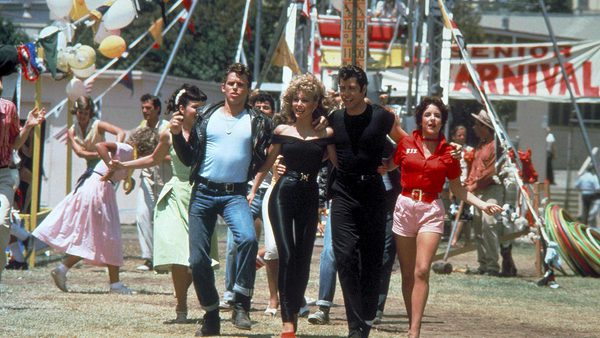 An image from the film 'Grease' of Sandy, Danny and their friends walking through a carnival.