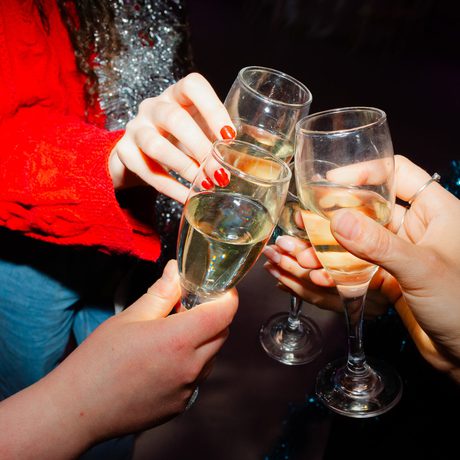 Three people cheers with champagne flutes